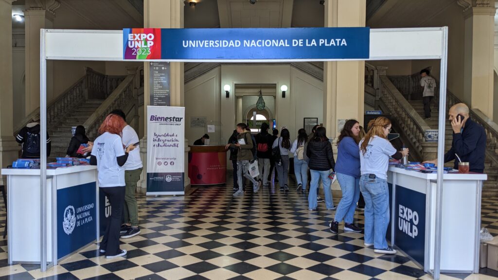 Fotografia del ingreso a la ExpoUNLP 2023, donde se puede ver el stand de bienvenida y el cartel que dice Universidad Nacional de La Plata.